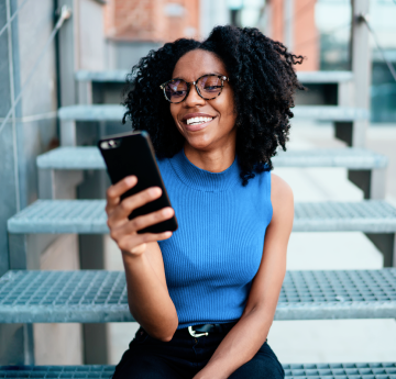 Pessoa com celular na mão sorrindo